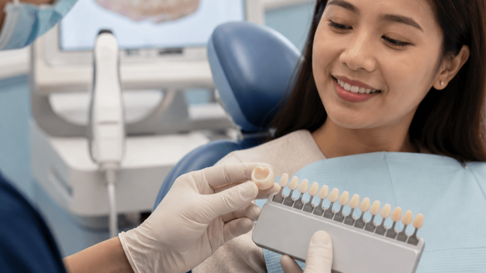 Dentist showing a dental crown and shade guide to a patient in Johor Bahru