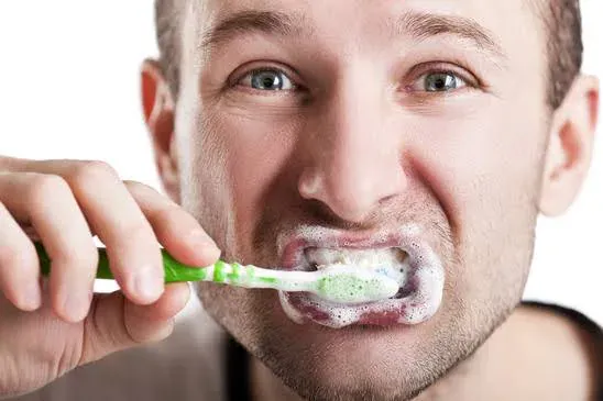A person brushing forcefully with a toothbrush